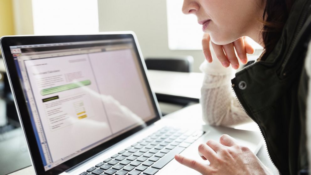 Side view of a woman using a laptop