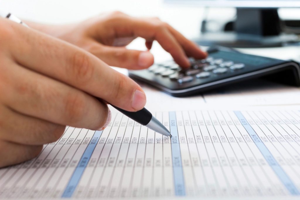 Close-up of a person adding numbers on a calculator