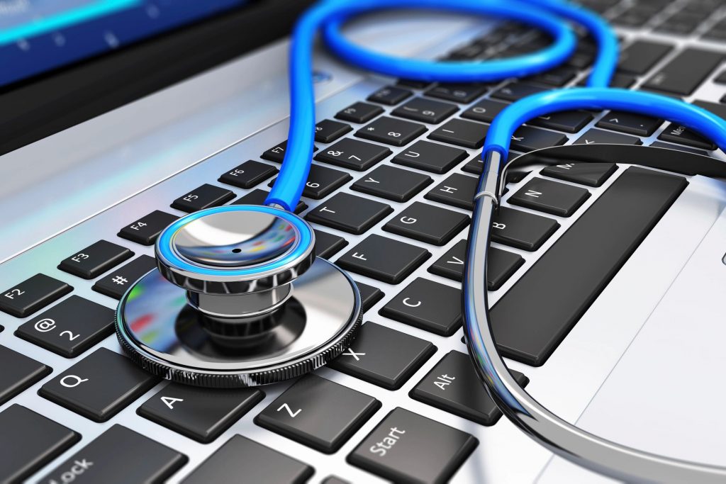 A blue stethoscope on a laptop keyboard