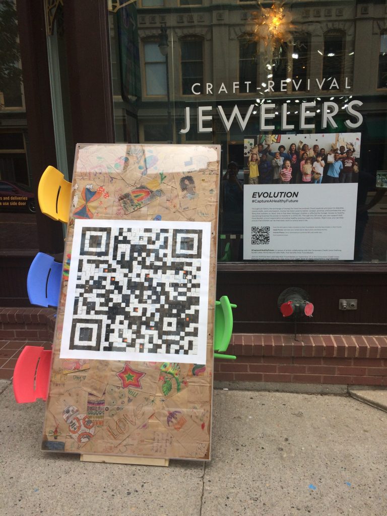 A table with colorful chairs on display in front of a jewelry storefront