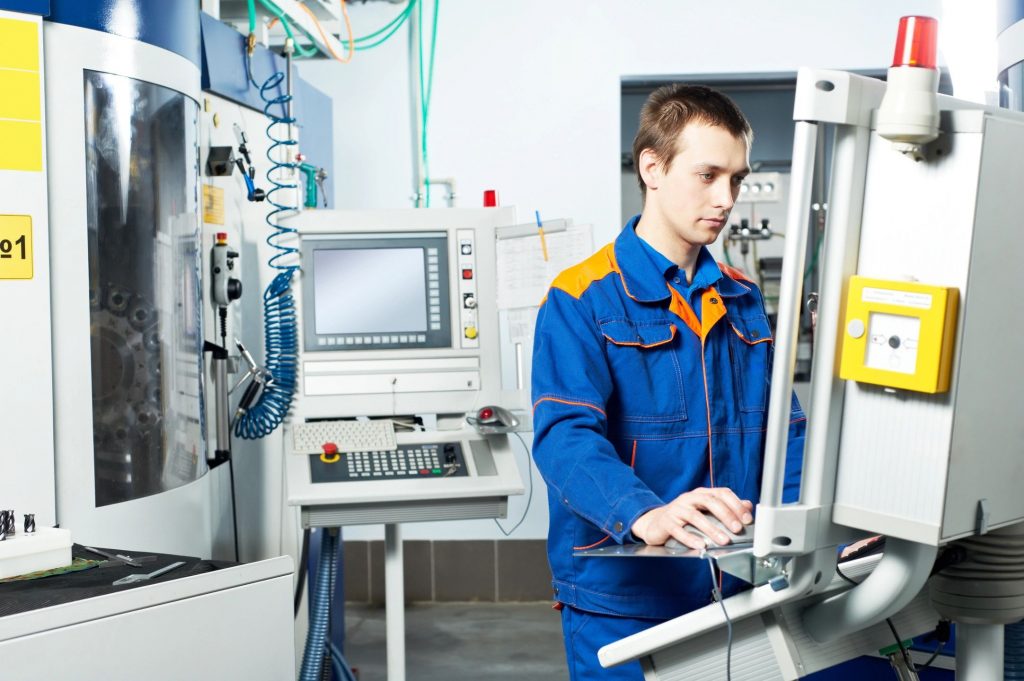 A young man working on a machine in a robotics lab