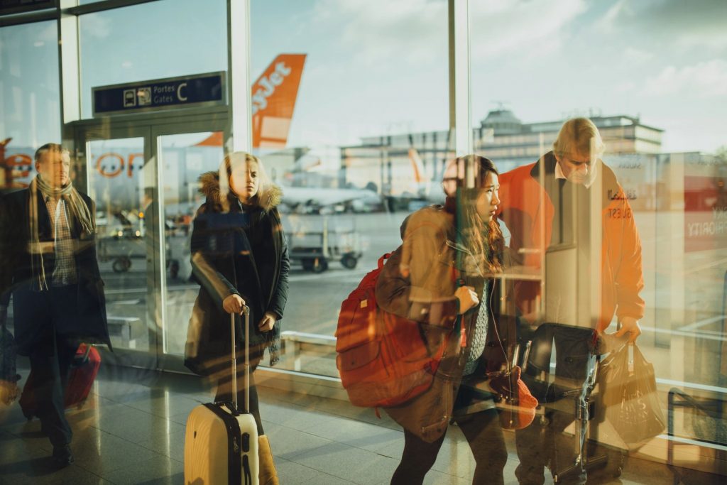 Travelers walking through an airport terminal with their luggage