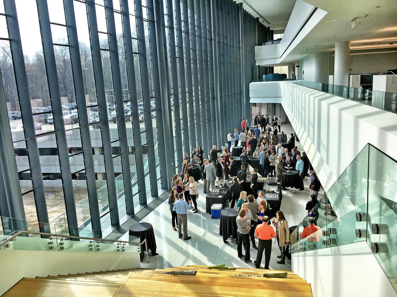 A view from atop a stairwell of a cocktail party in the atrium of an office building