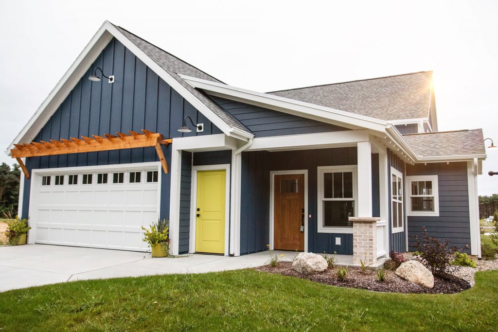 Blue house with white trim, grey roof, and yellow door