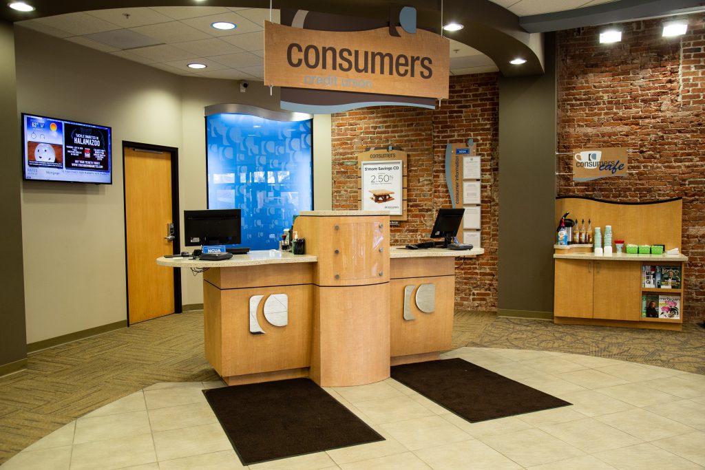 A customer service stations with silver Consumers Credit Union logos