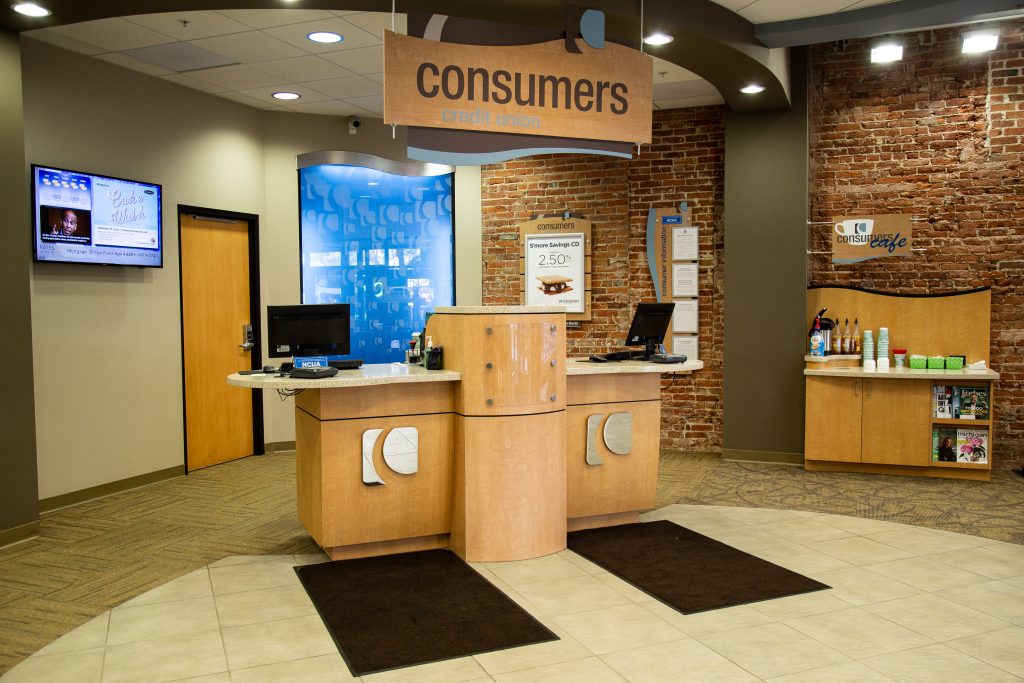 A customer service stations with silver Consumers Credit Union logos