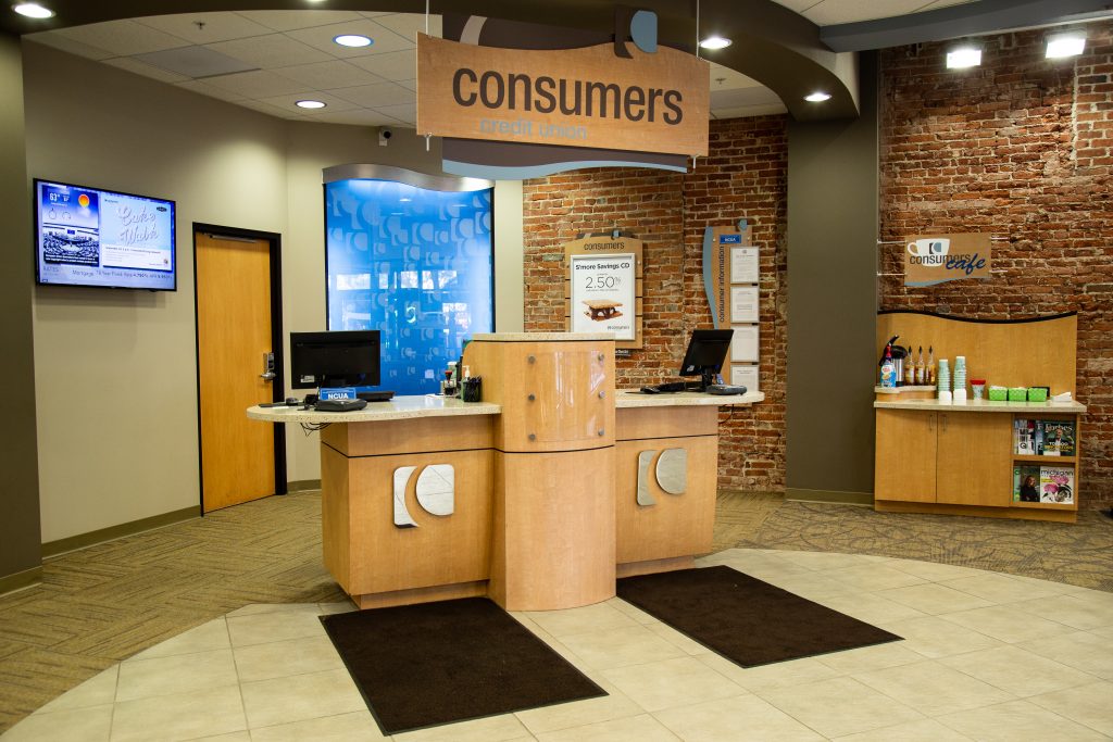 A customer service stations with silver Consumers Credit Union logos