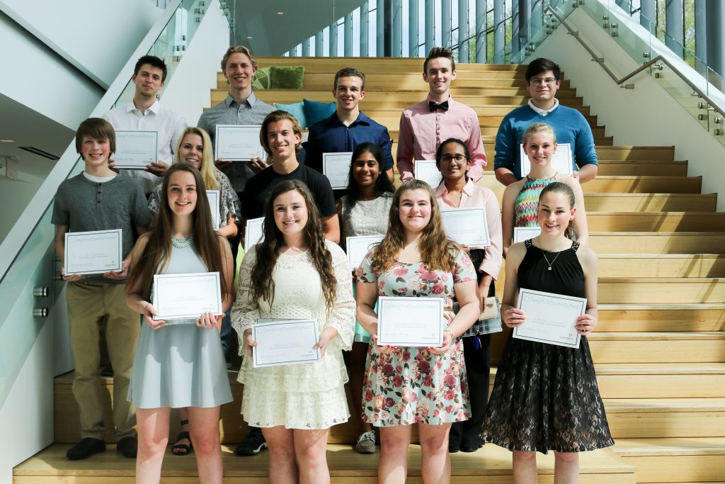 A group of students standing on steps holding certificates