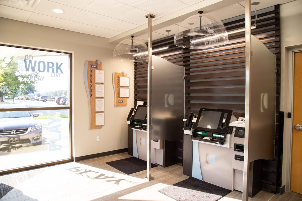 Two self-service tellers next to large window in a Consumers Credit Union