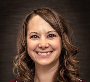 A brunette smiling for a professional headshot