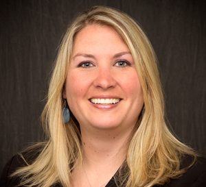 A woman with long blonde hair smiling for a headshot