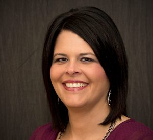 A woman with black hair smiling for a headshot photo