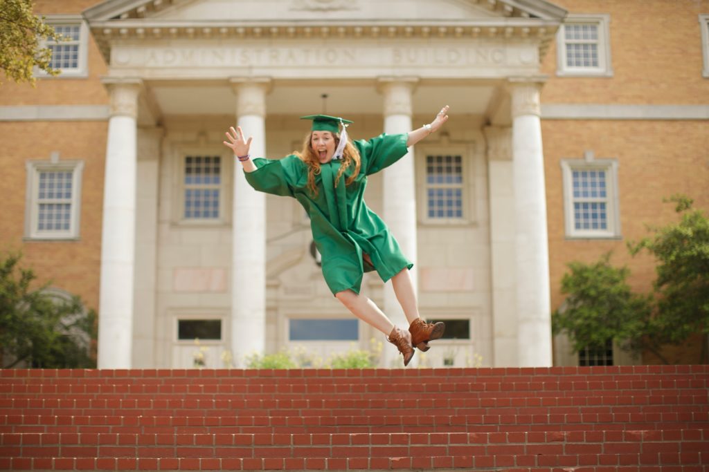 Female graduate jumping excitedly