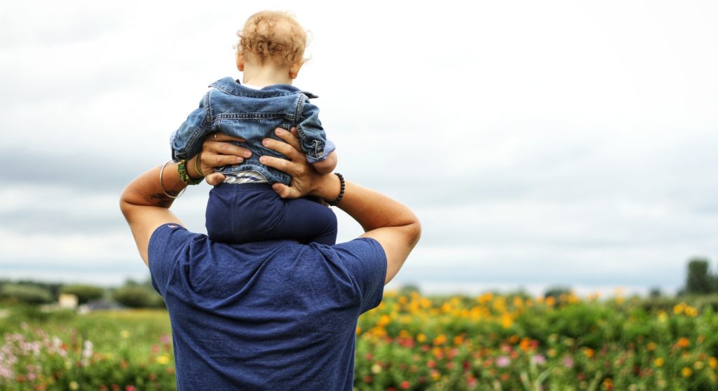 Father holding small child on his shoulders