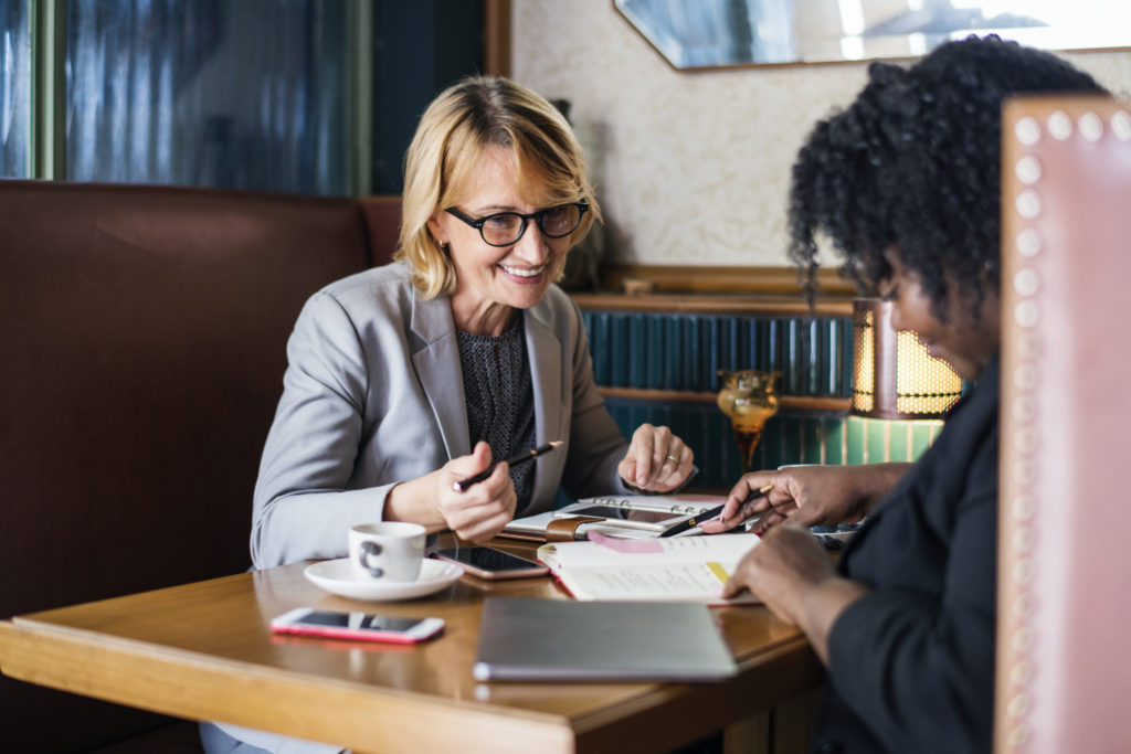 Two women sitting at a table for a business meeting