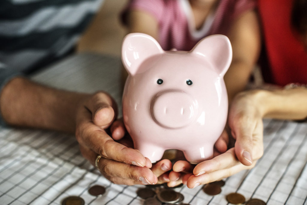 Person holding pink piggy bank