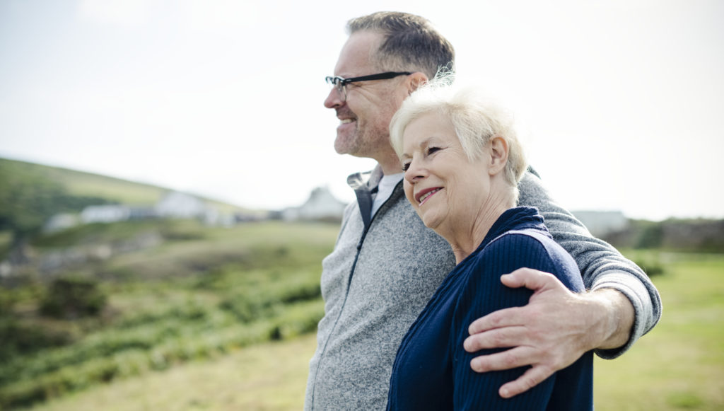 Smiling man with his arm wrapped around a woman's left shoulder