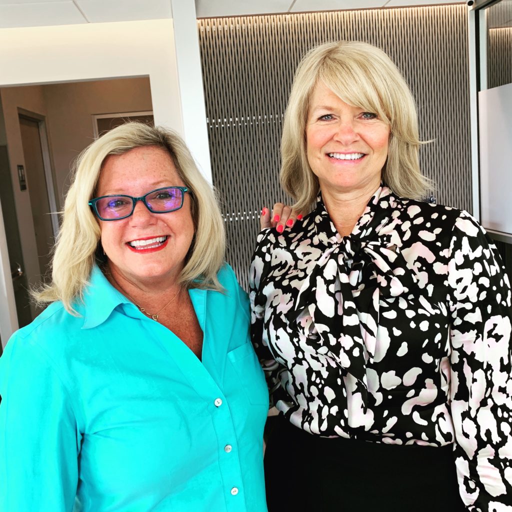 two women pose together with smiles