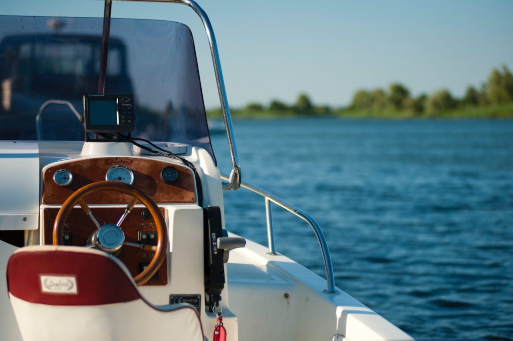 white and brown boat floating in lake