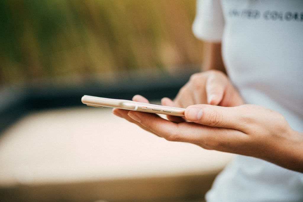 Up close photo of woman standing and holding a phone