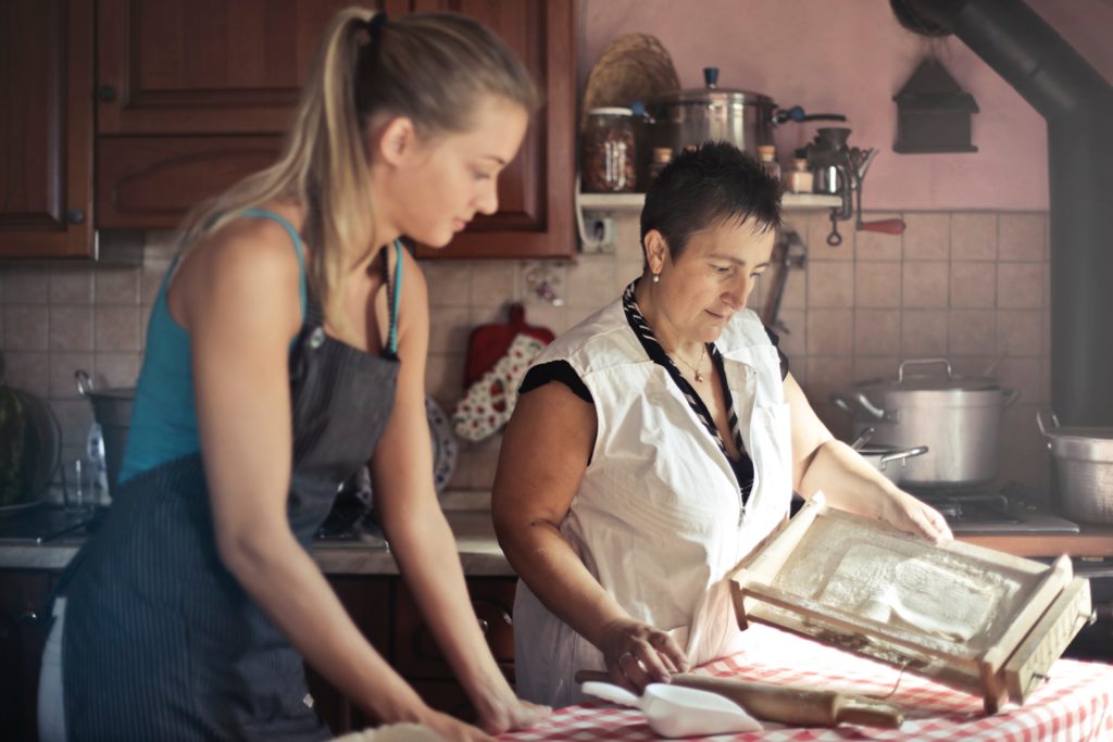 A mother teaching her daughter how to bake