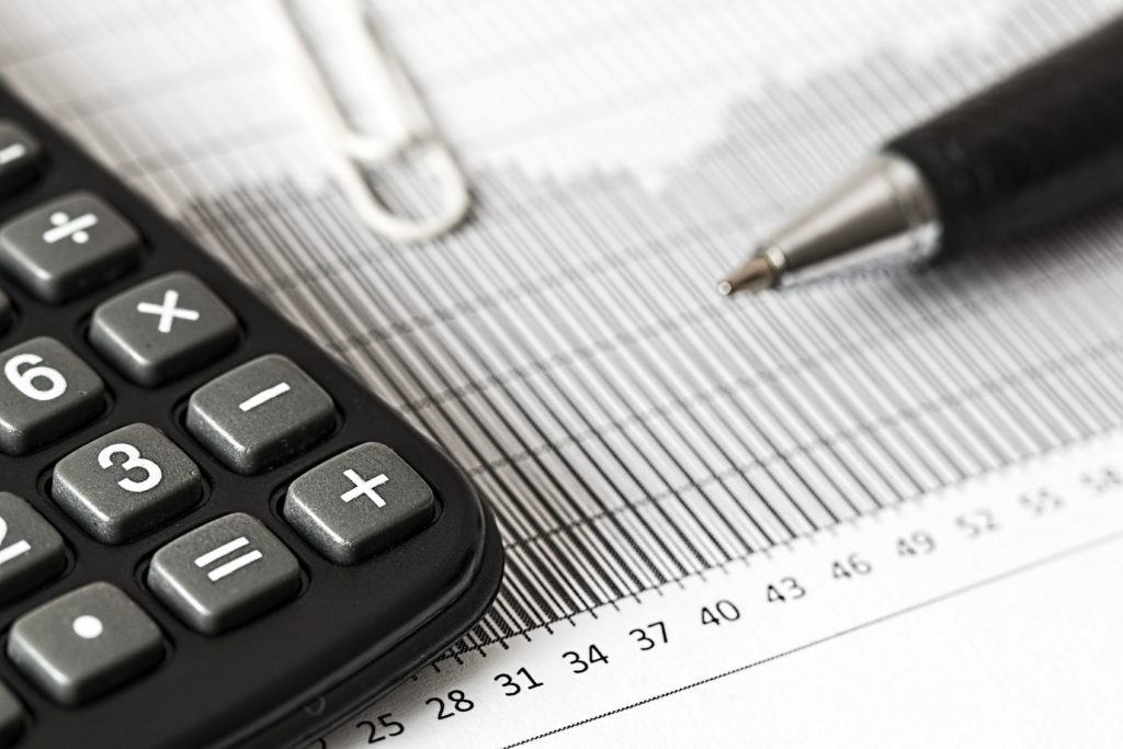 Calculator and pen on a table with financial documents