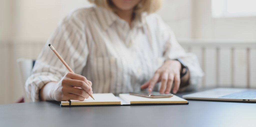 Person writing on notebook