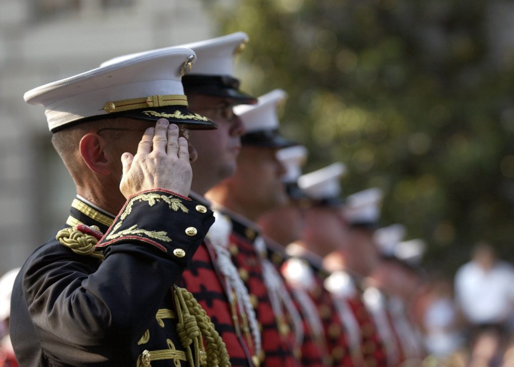 Military personnel in a line saluting